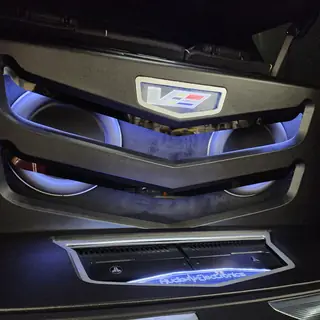Custom trunk with two subwoofers, an amplifier, blue LED lighting and a Cadillac V emblem